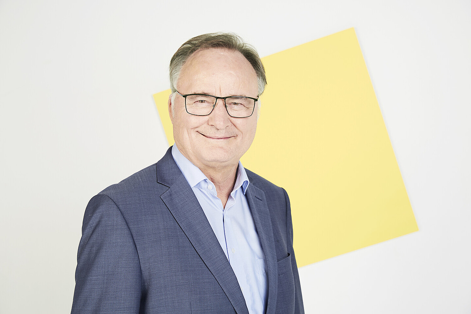 Porträt von Erhard Rahm vor einer quadratischen gelben Fläche