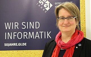 Portraitfoto von Prof. Dr. Daniela Nicklas vor GI-Hintergrund mit Text "Wir sind Informatik"