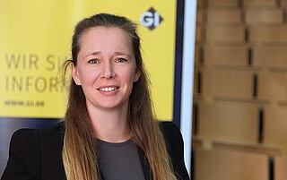 Portraitfoto von Prof. Dr. Ulrike Lucke vor GI-Hintergrund mit Text "Wir sind Informatik"